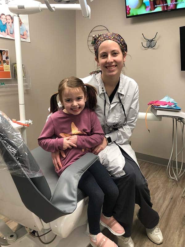 dental associate with young smiling patient