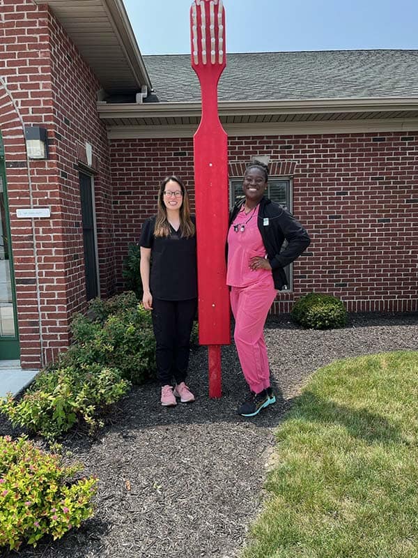 two dental associates with oversized toothbrush