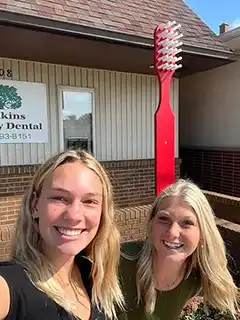 Smiling women with large red toothbrush