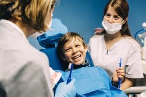 doctor dentist teaching a child to brush teeth